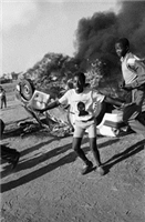 Youths celebrating the burning of a suspected informer's car after the funeral of Duduza comrades killed by grenades in a police 'sting' operation. Bishop Tutu had addressed the funeral and saved the driver before he was attacked